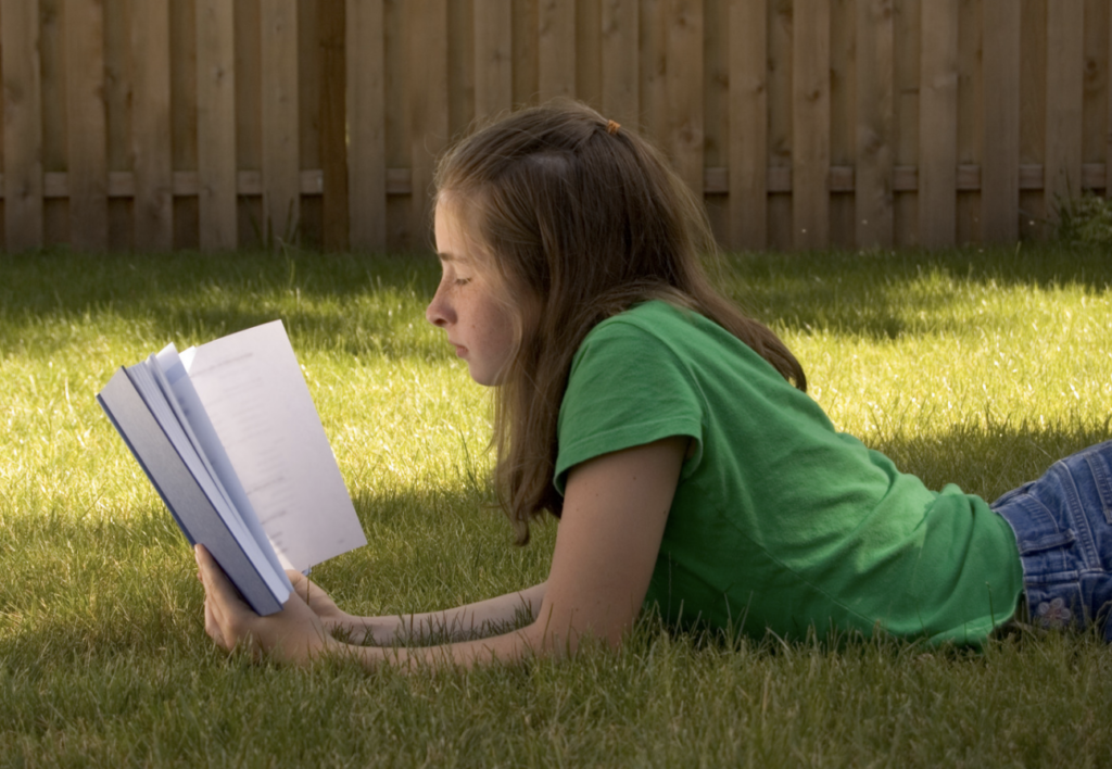 girl reading outside in summer